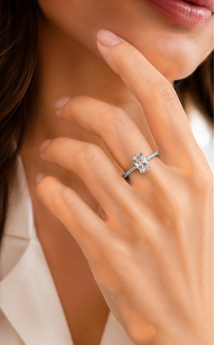 Yoniq.woman adjustable silver-tone ring with a radiant emerald-cut cubic zirconia stone and pavé band on a finger.