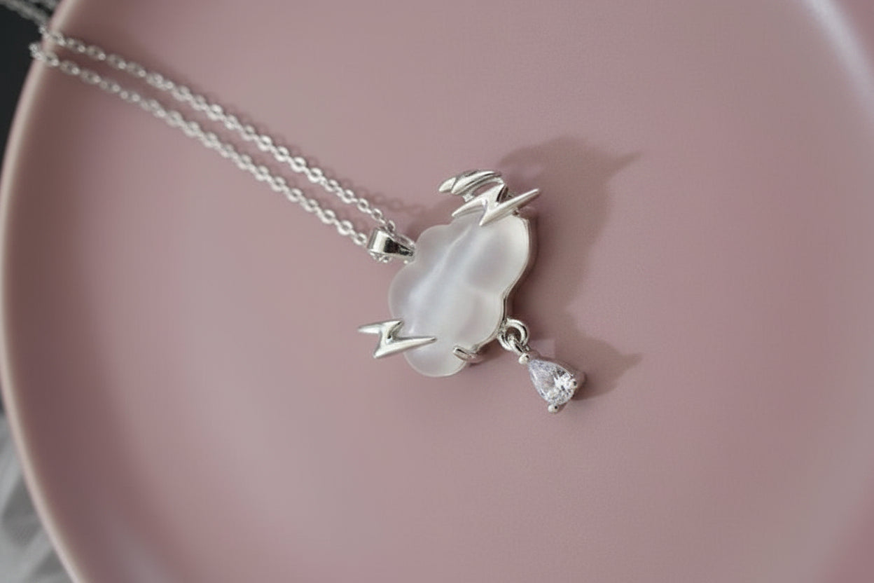Yoniq.woman silver cloud pendant necklace with lightning bolts and a dangling crystal teardrop charm