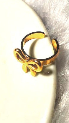 Yoniq.woman gold-tone adjustable finger ring featuring a delicate polished bow design on a white surface