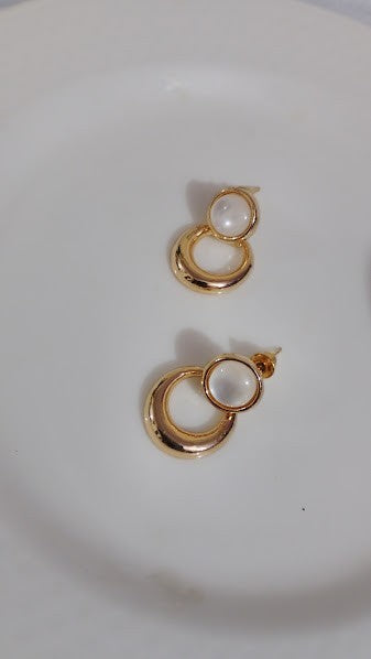 Yoniq.woman gold-tone drop earrings featuring a polished circular base and a smooth white cabochon stud.