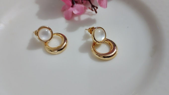Yoniq.woman gold-tone drop earrings featuring a polished circular base and a smooth white cabochon stud