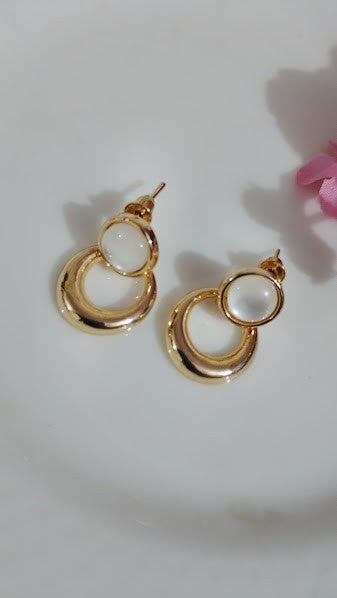 Yoniq.woman gold-tone circular drop earrings featuring a polished metallic finish and smooth white cabochon studs.
