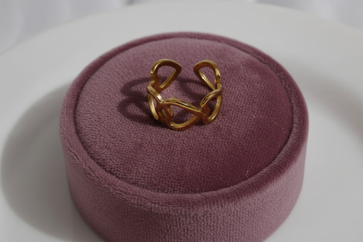 Yoniq.woman gold-tone adjustable statement ring featuring a continuous open heart design on a white surface.