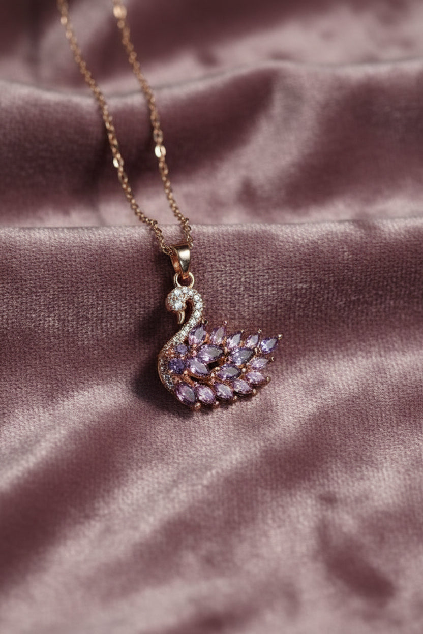 Yoniq.woman rose gold swan pendant necklace with purple marquise-cut crystals and pavé detailing on a delicate chain.