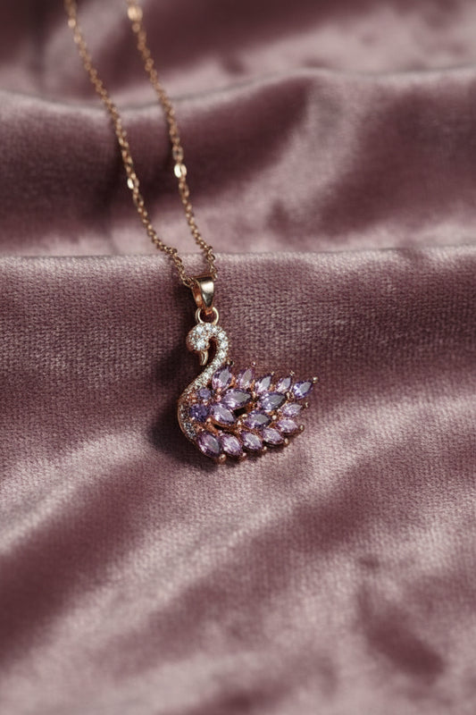 Yoniq.woman rose gold swan pendant necklace with purple marquise-cut crystals and pavé detailing on a delicate chain.