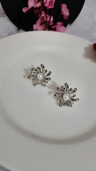 Yoniq.woman silver-tone floral stud earrings featuring an abstract petal design and a central faux pearl accent.