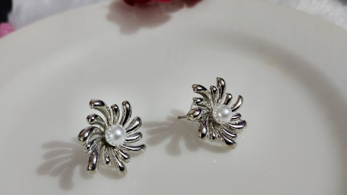 Yoniq.woman silver-tone floral stud earrings featuring an abstract petal design and a central faux pearl.