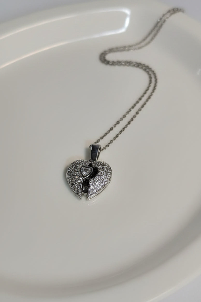 Yoniq.woman silver-tone heart locket necklace featuring a split-heart design with shimmering cubic zirconia stones.