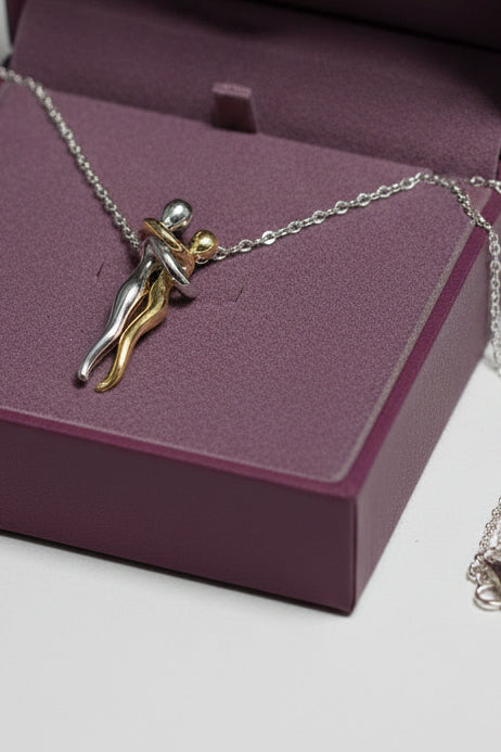 Yoniq.woman two-tone intertwined couple pendant necklace in polished gold and silver metal on a delicate chain